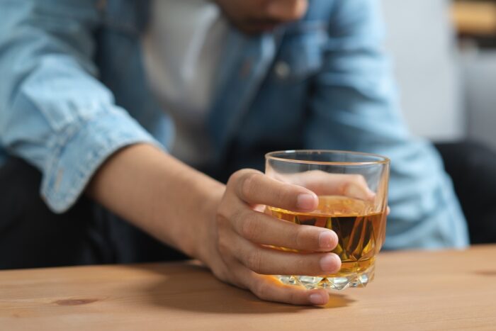 アルコールやタバコに溺れ、依存している男